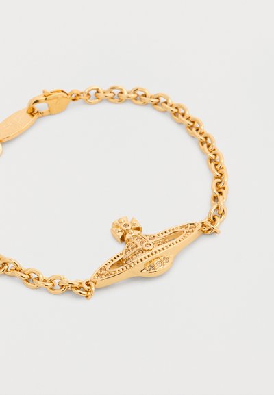 Βραχιόλι χρυσής αλυσίδας με μια λεπτομερή σφαιρική γοητεία που περιλαμβάνει έναν σταυρό και διακοσμητικές χαράξεις σε λευκό φόντο.