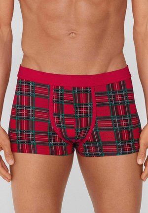 Červené kostkované boxerky se zelenými a černými akcenty, s měkkým pasem a přiléhavým střihem. Materiál se jeví jako hladký a elastický.