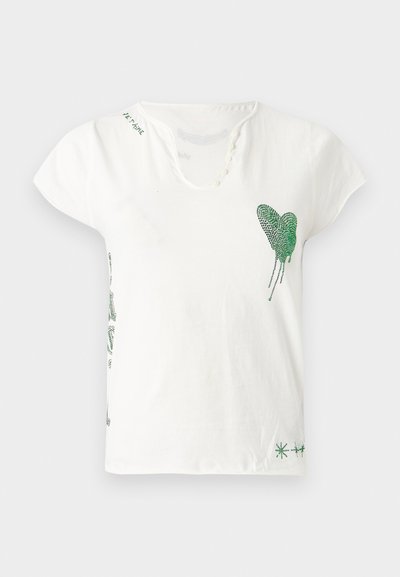 Άσπρο βαμβακερό μπλουζάκι με στρογγυλή λαιμόκοψη, κοντά μανίκια και σχέδιο πράσινης κρυστάλλινης καρδιάς στο αριστερό στήθος. Διακοσμητικά πράσινα στοιχεία.