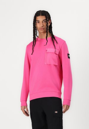 Pink sweatshirt made of soft fabric, featuring a front pocket with a zipper, ribbed cuffs, and a black label on the sleeve.