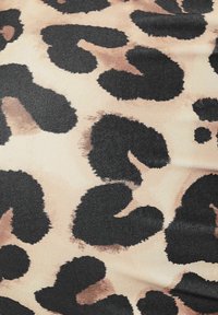 Leopardprint stof met grote zwarte en bruine vlekken op een beige achtergrond. De textuur is glad en licht glanzend.