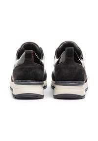 Chaussures en cuir suédé noir et en cuir verni, avec un accent contrastant en brun foncé, dotées d'une semelle rembourrée et d'une languette à l'arrière.