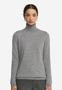 Grauer Rollkragenpullover aus weichem Stoff. Figurbetonter Schnitt mit langen Ärmeln und geripptem Kragen. Glatte Textur mit zarten Nähten.