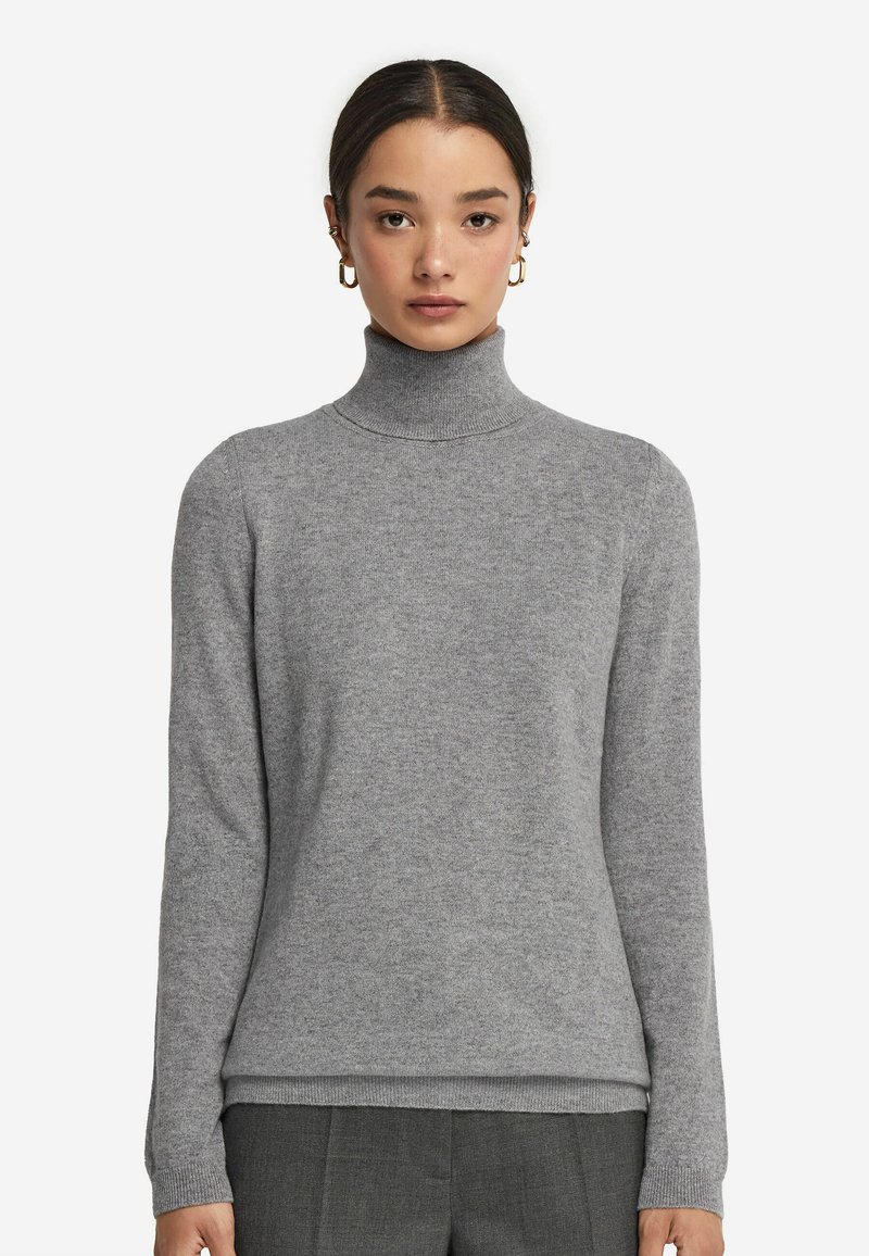 Grauer Rollkragenpullover aus weichem Stoff. Figurbetonter Schnitt mit langen Ärmeln und geripptem Kragen. Glatte Textur mit zarten Nähten.