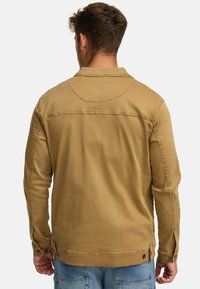 Khaki jakke, bomuldsstof, lange ærmer, klassisk krave, rygskøde detail, trykknapmanchetter og justerbar bund med knapper.