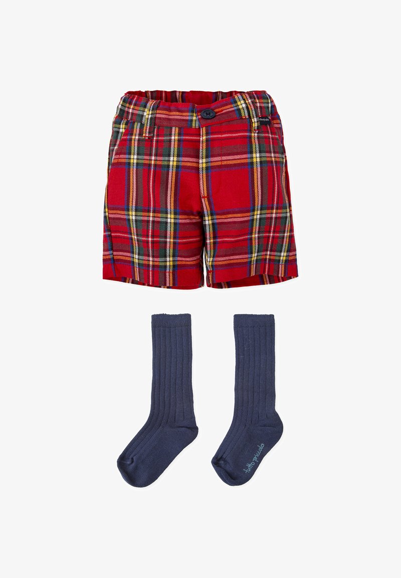 Pantalones cortos de cuadros rojos con líneas amarillas, verdes y azules; presenta un botón y una cintura elástica. Acompañados de calcetines de canalé azul oscuro.