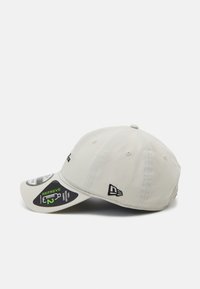 Helle graue Baseballcap mit einem gebogenen Schirm, ausgestattet mit einem gestickten Logo, einem verstellbaren Riemen und Etiketten aus recyceltem Material an der Seite.