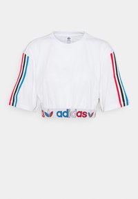 Bílý zkrácený tričko s krátkým rukávem, které má modré, červené a černé pruhy na rukávech a elastický pás se znakem.