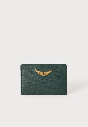 Porte-cartes en cuir texturé vert foncé avec une petite paire d’ailes décoratives dorées à l’avant sur fond blanc.