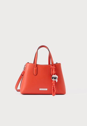 Mala vermelha sintética com duas pegas curtas e uma correia de ombro destacável. Apresenta um pendente e uma placa com o logótipo da marca na parte da frente.