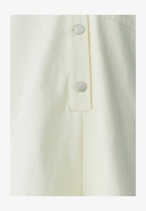 Tissu jaune clair, texturé avec un motif côtelé. Doté de boutons-pression argentés et d'un pli net sur le côté. Design minimaliste.