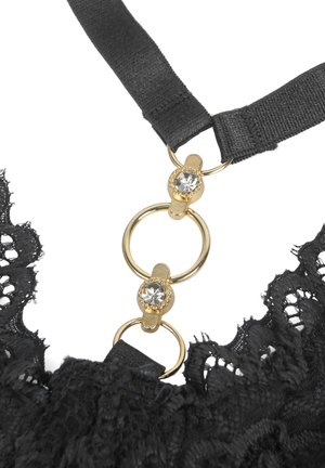 Black lace fabric with two black straps connected by gold rings adorned with clear rhinestones, forming part of a garment.