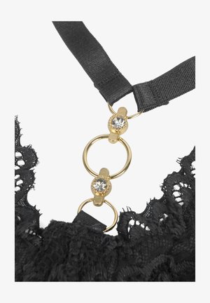Black lace fabric with two black straps connected by gold rings adorned with clear rhinestones, forming part of a garment.