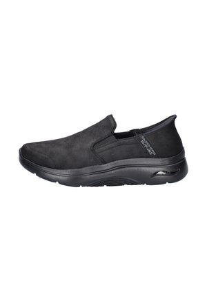 Chaussures noires à enfiler en matériau semblable au daim, avec une texture lisse, un bout arrondi et une semelle rembourrée conçue pour le confort.