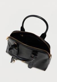 Μαύρη δερμάτινη τσάντα με χρυσό φερμουάρ, στρογγυλή λαβή και δύο λουριά. Το εσωτερικό διαθέτει μία μόνο θήκη και μία μικρή τσέπη με φερμουάρ. Λείος υφή.