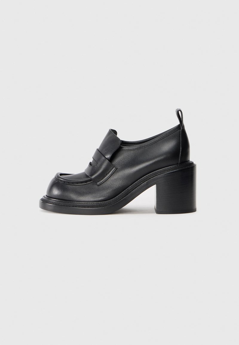Pantofi cu toc din piele neagră, cu vârf rotund, bandă proeminentă pe partea superioară și un design cu toc chunky. Textură netedă, cu cusături minime.