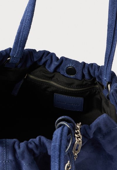Navyblauwe suède handtas met een geplooide opening, een binnenritszakje en een leren label. Voorzien van zilverkleurige kettingaccenten en een zachte textuur.