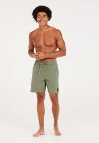 Groene zwemboxers met een elastische tailleband, verstelbaar trekkoord en zijzakken. Gemaakt van lichte stof, met een klein logo label.