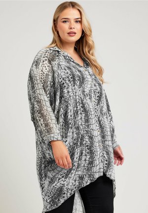 Durchsichtige, leichte Button-up-Bluse mit einem schwarz-weißen Tiermuster, ausgestattet mit einem Kragen und langen Ärmeln, schichtweise geschnitten mit einem asymmetrischen Saum.