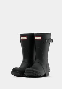 Μα�ύρες καουτσούκ μπότες βροχής με λείο εξωτερικό, στρογγυλή μύτη και ανάγλυφο λογότυπο. Διαθέτουν ρυθμιζόμενη λωρίδα με μεταλλική αγκράφα και υφασμένα σόλα.