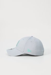 Gorra gris con visera curvada, con acentos en teal y detalles bordados en la parte frontal y lateral. Hecha de un tejido con textura suave.