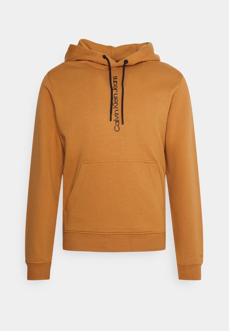 Bruine hoodie met een voorzak, met een zwart "Calvin Klein Jeans" logo. Gemaakt van zacht materiaal, met ribbels aan de mouwen en onderkant.