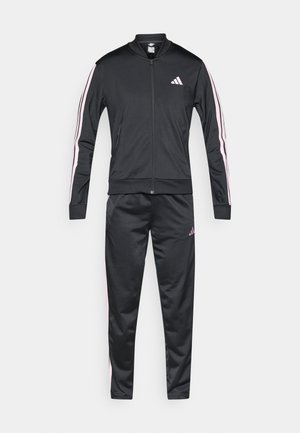 Chándal deportivo negro hecho de tela suave, que incluye una chaqueta con cremallera y una franja rosa de acento, y pantalones a juego con detalle de logo.