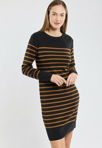 Robe en tricot à manches longues, avec des rayures horizontales noires et oranges. Encolure ronde et détail d'entoilage sur le côté, texture douce.