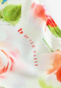 Material textil floral cu o textură satinat, prezentând nuanțe moi de roz și verde. Logo-ul imprimat "BY TED BAKER" în roșu în partea de jos.