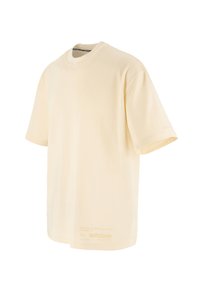 Cream-colored T-shirt, cotton material, short sleeves, crew neckline, featuring printed text near the hem on the front.