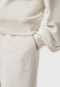 Hellbeige Sweatshirt mit gerippten Bündchen und Saum. Verfügt über ein dezentes geprägtes Logo-detail im Taschenbereich. Der Stoff ist weich und strukturiert.