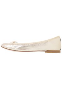 Bailarina metálica dorada con punta redondeada, ribete de tela y un pequeño lazo decorativo. Tacón plano con un acento de madera en la parte trasera.