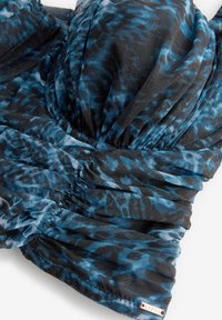 Top bikini arricciato in nero con stampa animale blu. Realizzato in tessuto leggero, presenta una texture liscia e un'etichetta del marchio discreta.