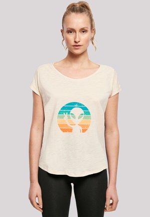 Light beige short-sleeve t-shirt with a scoop neckline, featuring a colorful alien graphic in a circular design. Textured, relaxed fit.