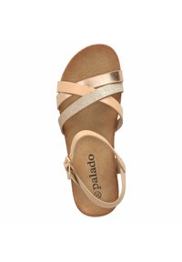 Sandalo beige con cinturini incrociati, uno dei quali presenta una finitura metallica dorata e l'altro ha una texture glitterata. Suola imbottita e fibbia regolabile.