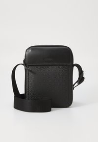 Borsa a tracolla nera in materiale sintetico testurizzato, con motivo a logo ripetuto e tracolla regolabile. Pannello frontale liscio.