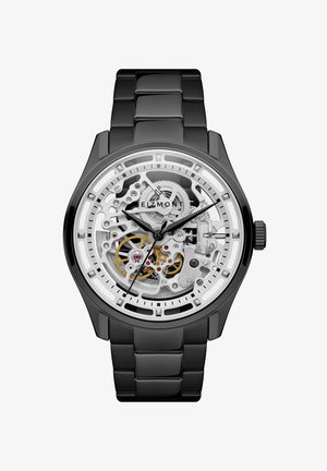 Svart metallklokke med skjelettskive som viser sølv- og gullfargede gir, svarte time- og minuttvisere, og "Eizmont" merkenavn på urskiven.