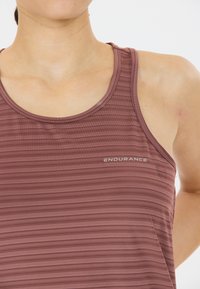 Bordeaux atletisch tanktop met verticale strepen, ronde halslijn en een gladde textuur. Bevat het "ENDURANCE" logo in een reflecterende zilveren kleur.
