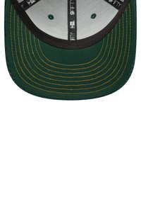 Gorra verde con una corona de color verde oscuro, visera negra y detalles de costura amarillos. El interior muestra un forro gris con marcas de etiqueta.