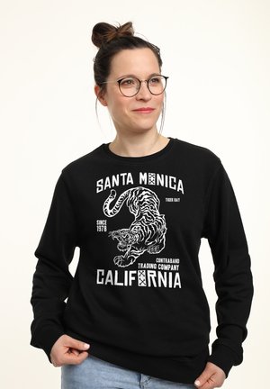 Czarny bawełniany sweatshirt z białym wzorem graficznym przedstawiającym tygrysa oraz napisy: „Santa Monica”, „Tiger Bay” i „Kalifornia”.