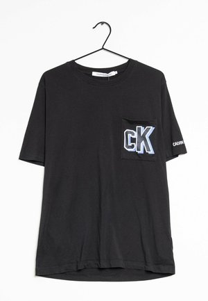 Sort T-shirt med korte ærmer og brystlomme, der har et blåt og hvidt "CK" logo. Stoffet ser glat og bomuldsagtigt ud i teksturen.