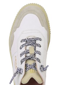 Biały skórzany sneaker z beżowymi zamszowymi akcentami, sznurowadła z nadrukiem w cętki o fakturze lamparcia oraz żółta gumowa podeszwa. Złote logo „CRICK” na boku.