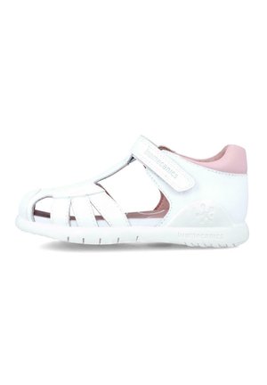 Sandalia blanca con puntera cerrada, diseño recortado, tira de Velcro y acentos de color rosa claro. Fabricada en material sintético con una suela texturizada.