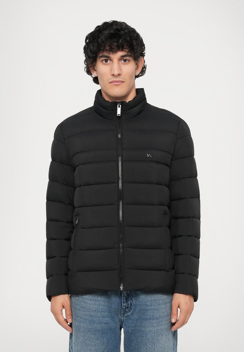 Jachetă puffer neagră cu guler înalt, design matlasat orizontal, fermoar frontal și buzunare laterale. Materialul pare neted și ușor.