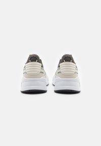 Sport sneakers met een witte tussenzool, zwarte buitenzool en grijze mesh bovenkant. Voorzien van een gevoerde hakcounter en textuuraccenten.