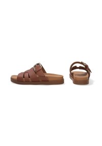 Braune Leder-Sandalen mit Kreuzriemen, einer Schnallenakzent und einer strukturierten, beigen Sohle. Flaches Design für lässigen Komfort.