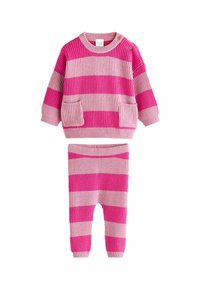 Stickad tröja i rosa och ljusrosa randigt mönster med två framfickor och knäppdetalj, kombinerad med matchande randiga leggings.