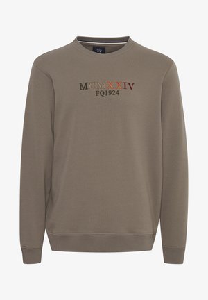 Gaiši brūns džemperis, izgatavots no kokvilnas maisījuma, ar ribotu apkakli un piedurknēm. Izšūts teksts daudzkrāsainās diegu krāsās krūtīs.