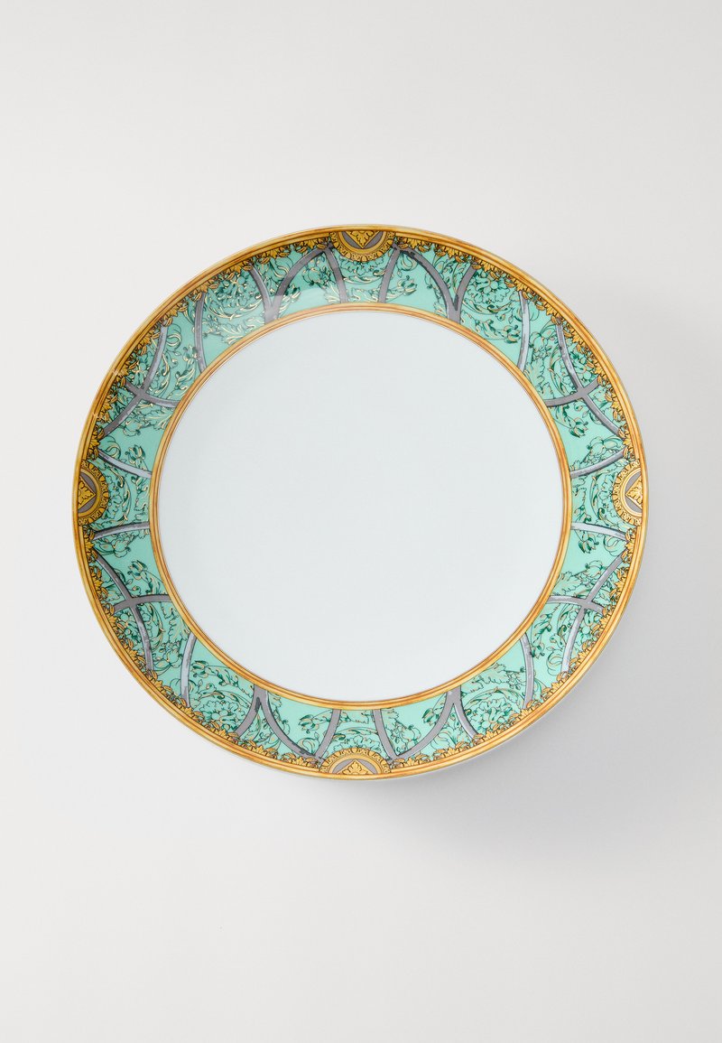 Κεραμικό πιάτο με τυρκουάζ διακοσμητικό περίγραμμα που περιλαμβάνει πολύπλοκα χρυσά στοιχεία, κέντρο λείο και λευκό, με κυματιστό σχέδιο περιγράμματος.