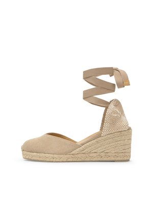 Espadrilla beige con zeppa, punta chiusa, cinturino intrecciato alla caviglia e suola platform in juta intrecciata.